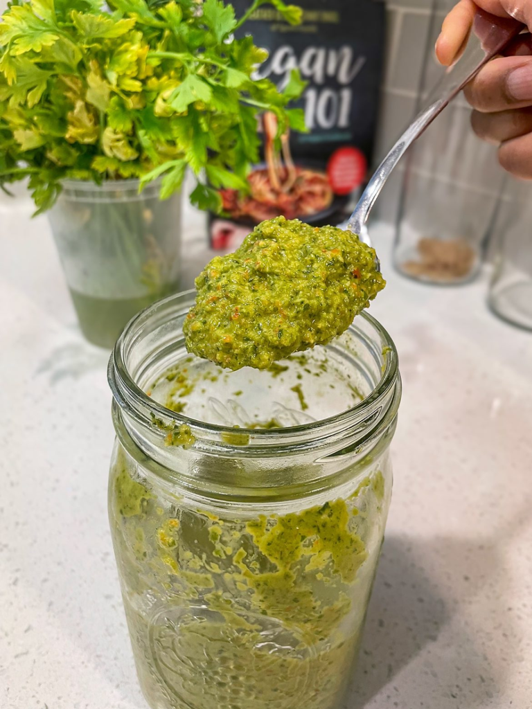 A picture of Haitian epis in a jar with a spoonful of the spice.