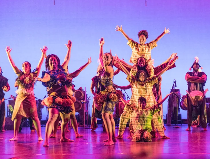 dancers on a stage in african tribal clothing.