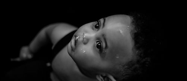 child in black and white looks like toddler with curly hair