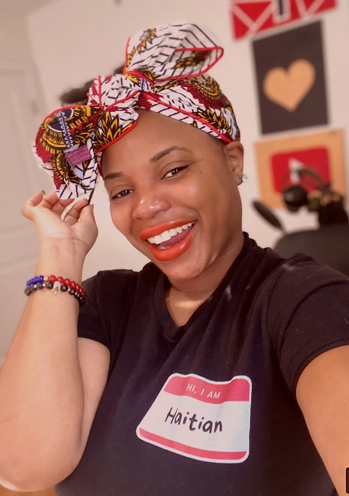 woman with wrapped hair and black shirt selfie shot. 