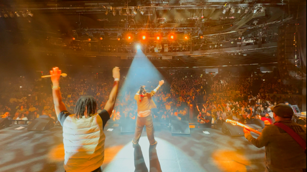 Alan Cave on stage in front of Madison Square Garden Crowd performing.